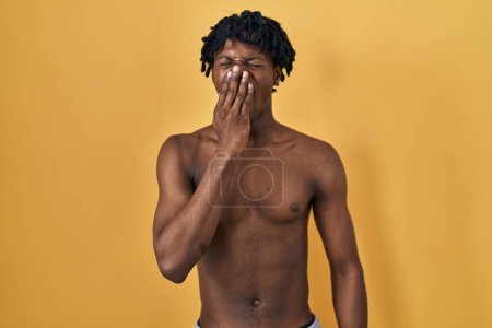 Photo for Young african man with dreadlocks standing shirtless bored yawning tired covering mouth with hand. restless and sleepiness. - Royalty Free Image