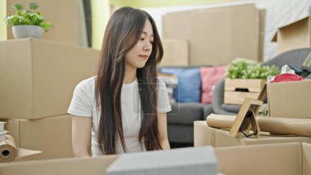 Photo for Young chinese woman looking photography at new home - Royalty Free Image