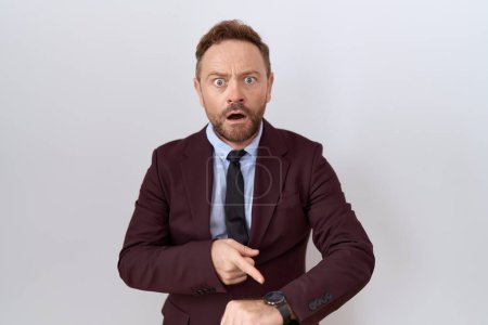 Photo for Middle age business man with beard wearing suit and tie in hurry pointing to watch time, impatience, upset and angry for deadline delay - Royalty Free Image