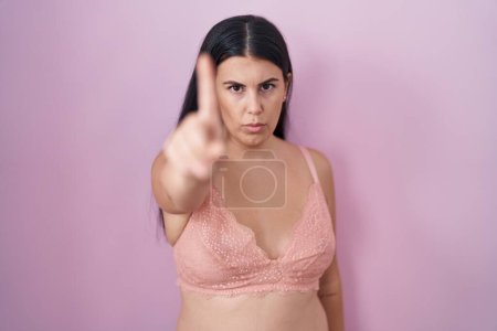 Photo for Young hispanic woman wearing pink bra pointing with finger up and angry expression, showing no gesture - Royalty Free Image