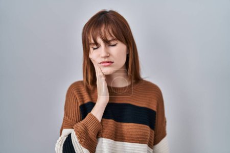 Photo for Young beautiful woman wearing striped sweater over isolated background touching mouth with hand with painful expression because of toothache or dental illness on teeth. dentist - Royalty Free Image