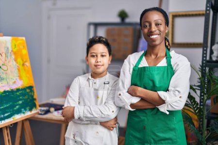 Photo for African american mother and son art student and teacher standing with arms crossed gesture at art studio - Royalty Free Image