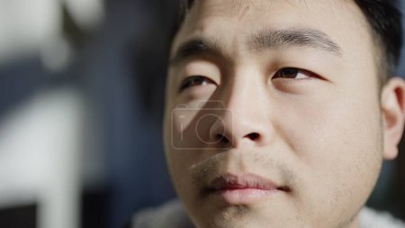 Photo for Young chinese man looking to the side with serious expression at street - Royalty Free Image