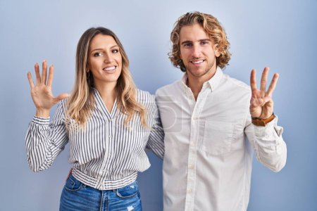 Photo for Young couple standing over blue background showing and pointing up with fingers number eight while smiling confident and happy. - Royalty Free Image