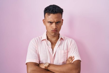 Téléchargez les photos : Young hispanic man standing over pink background skeptic and nervous, disapproving expression on face with crossed arms. negative person. - en image libre de droit