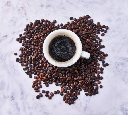 Foto de Una taza de café expreso y granos de café en la superficie de porcelana - Imagen libre de derechos