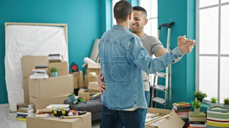 Photo for Two men smiling confident dancing at new home - Royalty Free Image