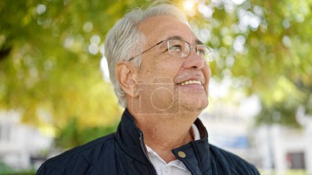 Photo for Middle age man with grey hair smiling confident looking up at park - Royalty Free Image