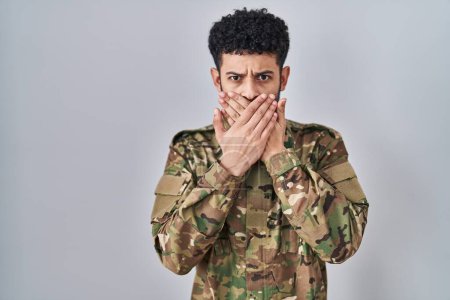 Photo for Arab man wearing camouflage army uniform shocked covering mouth with hands for mistake. secret concept. - Royalty Free Image
