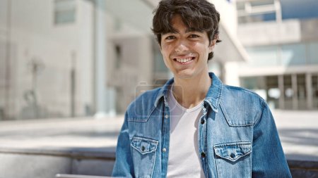 Téléchargez les photos : Jeune homme hispanique souriant confiance debout à l'université - en image libre de droit