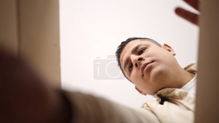 Foto de Joven hombre hispano desempacando caja de cartón en casa - Imagen libre de derechos
