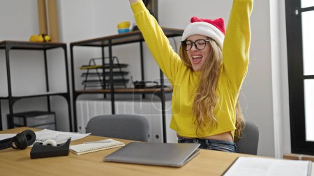 Téléchargez les photos : Jeune femme blonde femme d'affaires finissant le travail à partir de Noël vacances au bureau - en image libre de droit