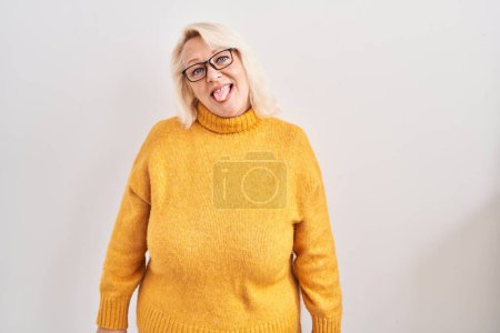 Téléchargez les photos : Moyen Age femme caucasienne portant des lunettes debout sur le fond langue collante heureux avec une expression drôle. concept d'émotion. - en image libre de droit
