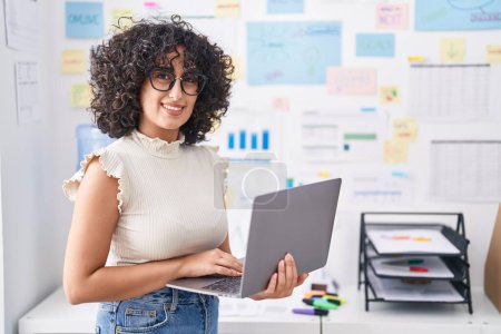 Téléchargez les photos : Jeune femme d'affaires du Moyen-Orient utilisant un ordinateur portable travaillant au bureau - en image libre de droit