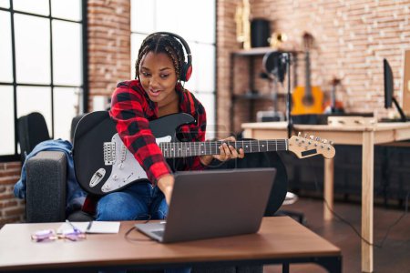 Téléchargez les photos : African american woman musician having online electrical guitar lesson at music studio - en image libre de droit