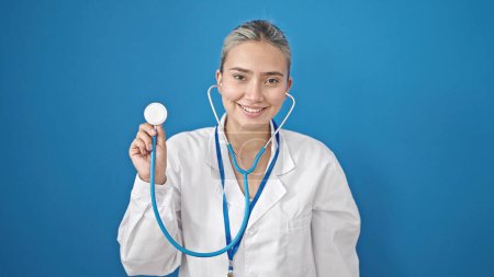 Photo for Young beautiful hispanic woman doctor smiling confident holding stethoscope over isolated blue background - Royalty Free Image