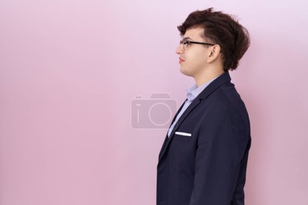 Photo for Young non binary man with beard wearing suit and tie looking to side, relax profile pose with natural face with confident smile. - Royalty Free Image