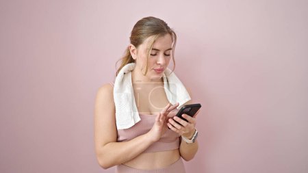 Photo for Young blonde woman wearing sportswear using smartphone over isolated pink background - Royalty Free Image