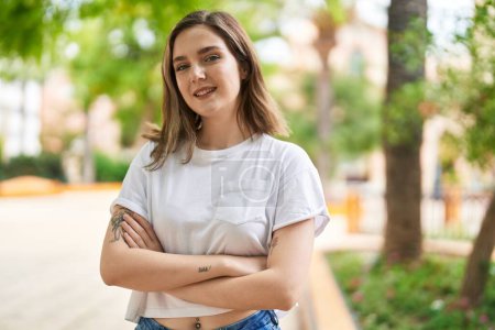 Téléchargez les photos : Young woman smiling confident standing with arms crossed gesture at park - en image libre de droit