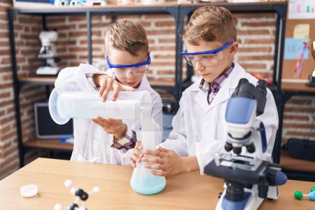 Photo for Adorable boys student pouring liquid on test tube at laboratory classroom - Royalty Free Image