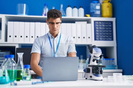 Foto de Joven científico hispano usando laptop trabajando en laboratorio - Imagen libre de derechos