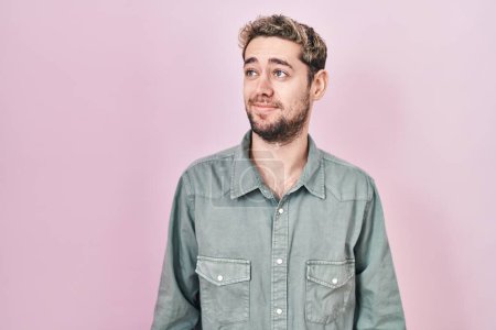 Photo for Hispanic man with beard standing over pink background smiling looking to the side and staring away thinking. - Royalty Free Image