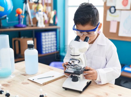 Photo for Adorable hispanic boy student using microscope at laboratory classroom - Royalty Free Image