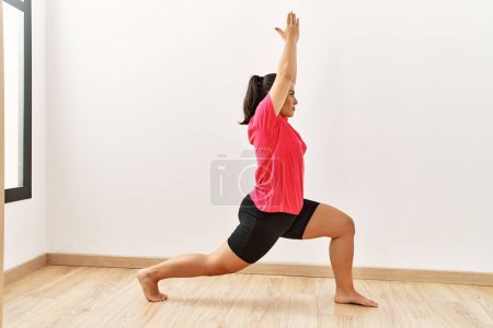 Foto de Joven hermosa mujer hispana entrenando yoga en el centro deportivo - Imagen libre de derechos