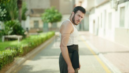 Photo for Young hispanic man karate fighter standing at park - Royalty Free Image