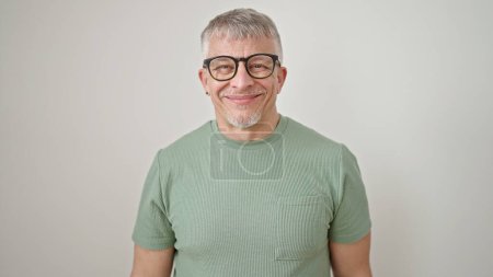 Foto de Hombre de pelo gris de mediana edad sonriendo confiado usando gafas sobre fondo blanco aislado - Imagen libre de derechos