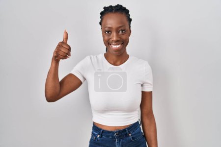 Photo for Beautiful black woman standing over isolated background doing happy thumbs up gesture with hand. approving expression looking at the camera showing success. - Royalty Free Image