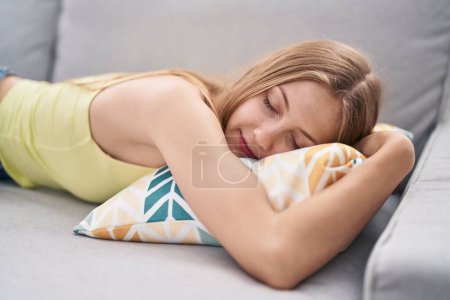 Photo for Young caucasian woman lying on sofa sleeping at home - Royalty Free Image