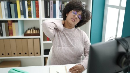 Téléchargez les photos : Jeune étudiante afro-américaine utilisant un ordinateur stressé dans une salle de classe universitaire - en image libre de droit