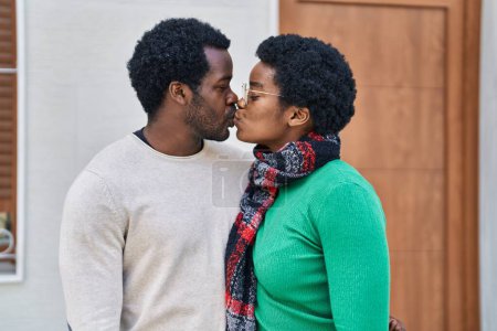 Téléchargez les photos : Africain américain homme et femme couple étreignant l'autre et s'embrassant dans la rue - en image libre de droit