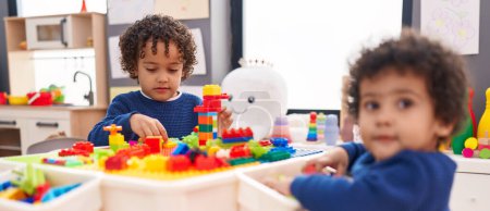 Photo for Adorable african american boys playing with construction blocks sitting on table at kindergarten - Royalty Free Image