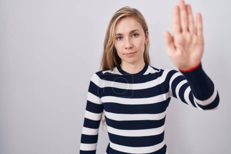 Photo for Young caucasian woman wearing casual navy sweater doing stop sing with palm of the hand. warning expression with negative and serious gesture on the face. - Royalty Free Image