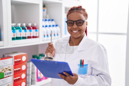 Photo for African american woman pharmacist organize shelving at pharmacy - Royalty Free Image