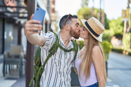 Foto de Hombre y mujer turista pareja sonriendo confiado hacer selfie por teléfono inteligente en la calle - Imagen libre de derechos