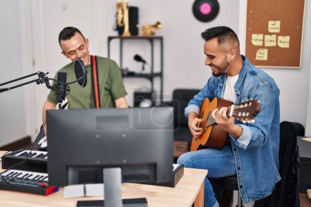 Photo for Two men musicians playing classical and electrical guitar at music studio - Royalty Free Image