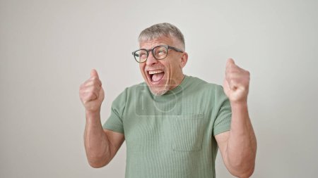 Téléchargez les photos : Homme aux cheveux gris d'âge moyen souriant debout confiant avec expression gagnante sur fond blanc isolé - en image libre de droit