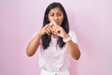 Téléchargez les photos : Jeune femme hispanique debout sur fond rose expression de rejet croisant les doigts faisant signe négatif - en image libre de droit