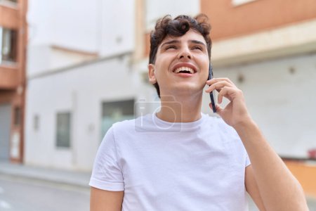 Photo for Non binary man smiling confident talking on smartphone at street - Royalty Free Image