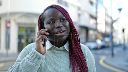 Photo for African woman with braided hair speaking on the phone at street - Royalty Free Image