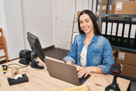 Foto de Joven mujer hispana hermosa comercio electrónico trabajador de negocios utilizando el ordenador portátil en la oficina - Imagen libre de derechos