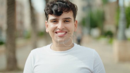 Téléchargez les photos : Non binary man smiling confident standing at park - en image libre de droit