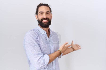 Foto de Hombre hispano con barba llevando camisa casual invitando a entrar sonriente natural con la mano abierta - Imagen libre de derechos
