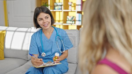 Téléchargez les photos : Jeune belle femme hispanique médecin prescrivant des pilules parler au patient à la clinique - en image libre de droit