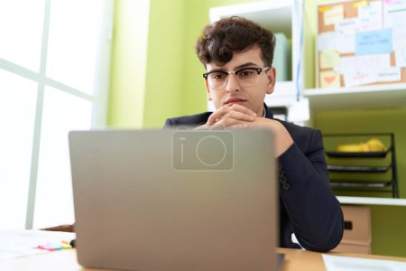 Photo for Non binary man business worker using laptop with relaxed expression at office - Royalty Free Image