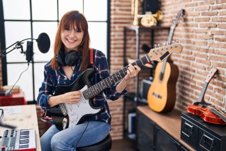 Téléchargez les photos : Jeune musicienne chantant une chanson jouant de la guitare électrique au studio de musique - en image libre de droit