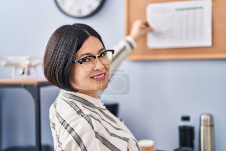 Photo for Young chinese woman business worker writing on cork board at office - Royalty Free Image